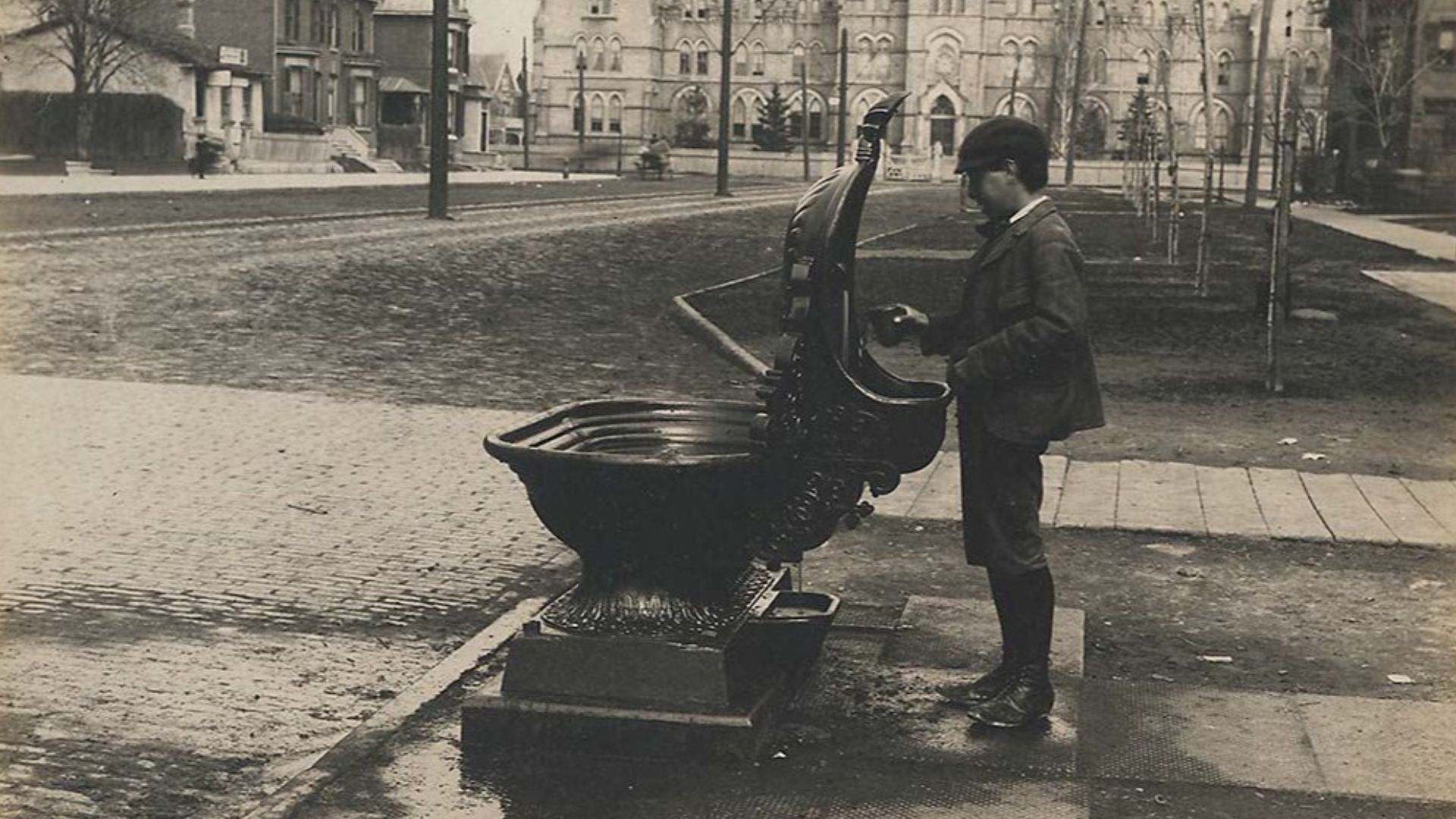 Commissioned by the City Engineer and taken by F.W. Micklethwaite, image shows a drinking fountain at College Street and Spadina Avenue, Toronto, Ontario, Canada.  Fountains such as this, designed to accomodate horses on one side and people on the other, 
