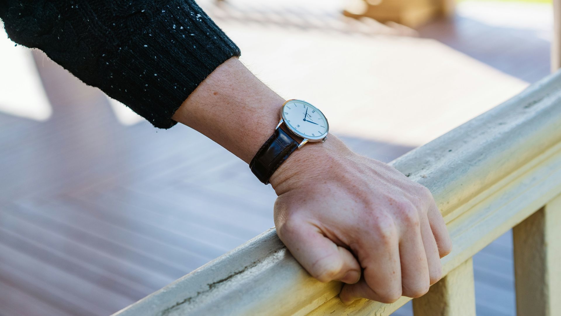 person wearing silver round analog watch