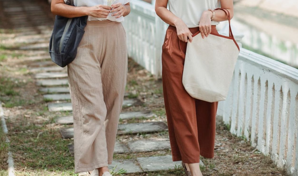 Two women enjoying a casual stroll outdoors on a sunny day, showcasing a relaxed urban lifestyle