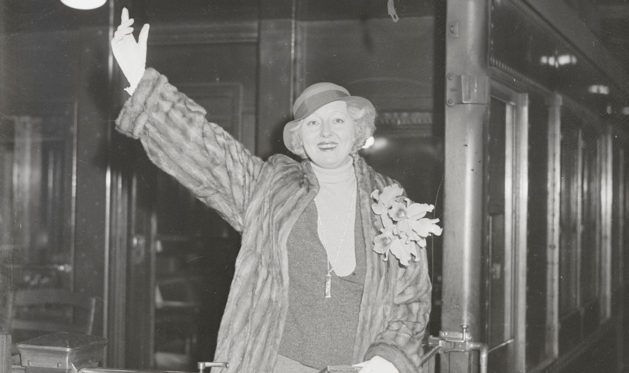 Peggy Hopkins Joyce Morner (who has had so many husbands that her public can't remember them all), bids goodbye to New York from the platform of the train that is speeding her toward Hollywood. There the orchidaceous lady will act in forthcoming cinemas. Fear of recent jewel thefts has prompted Peggy to leave behind her fortune in diamonds. She had intended to wear them to startle even the bizarre center of the cinema industry.