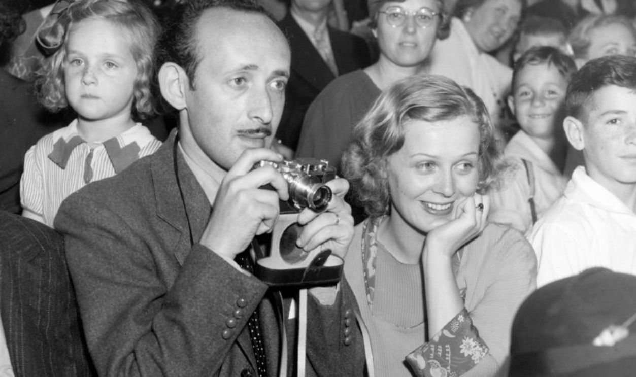 circa 1932: Gloria Stuart, the stage name of Gloria Stuart Finch ( 1909 - ) the American leading lady of the thirties is pictured standing by the side of her husband, Arthur Shackman, watching as he uses his 'Leica' camera.