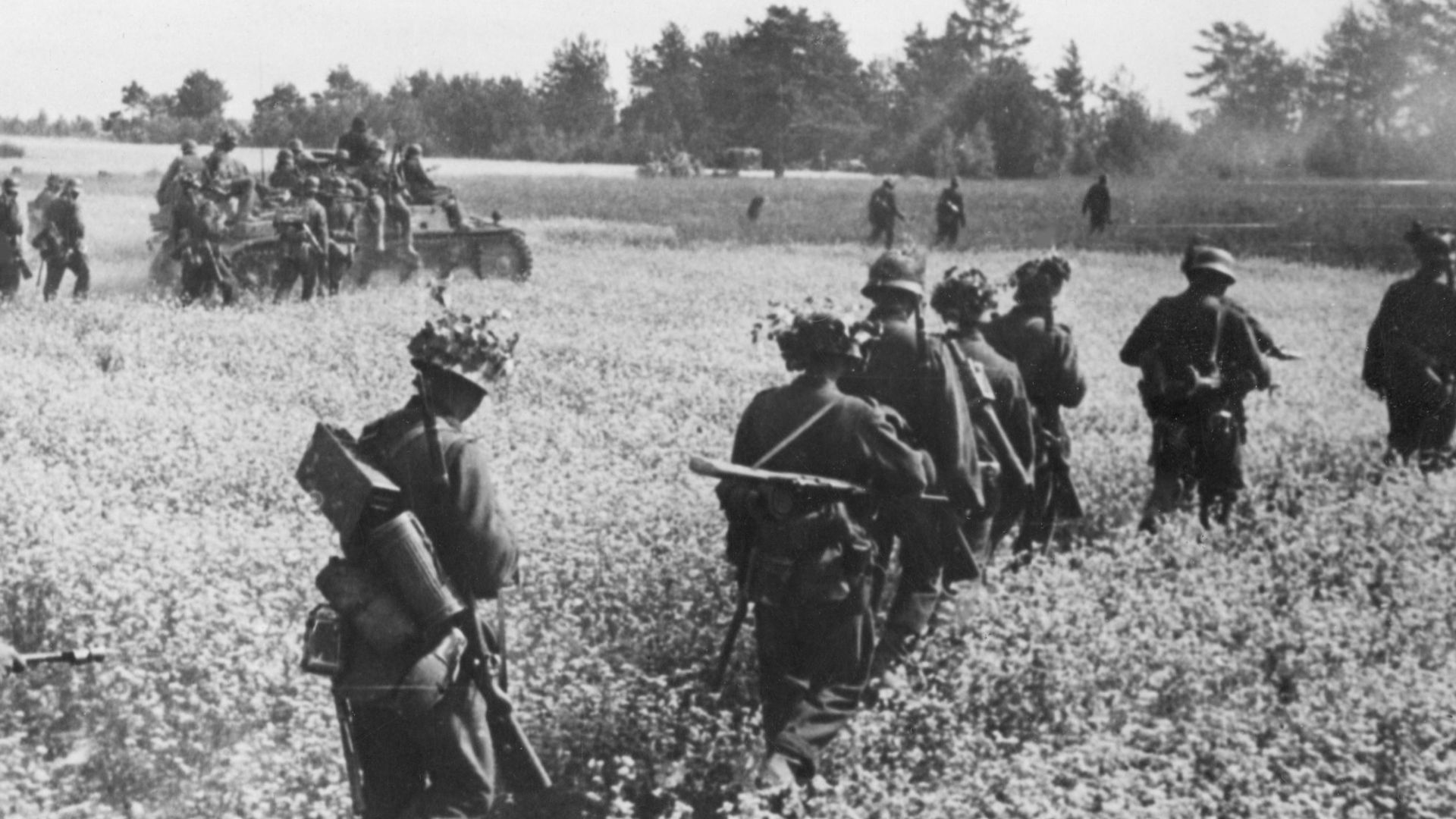 Niemiecka piechota i wojska pancerne wśród pól rzepakowych na froncie wschodnim. Widoczny wóz pancerny SdKfz 251, czołg PzKpfw II oraz żołnierz z karabinem przeciwpancernym Panzerbuchse PzB 39.