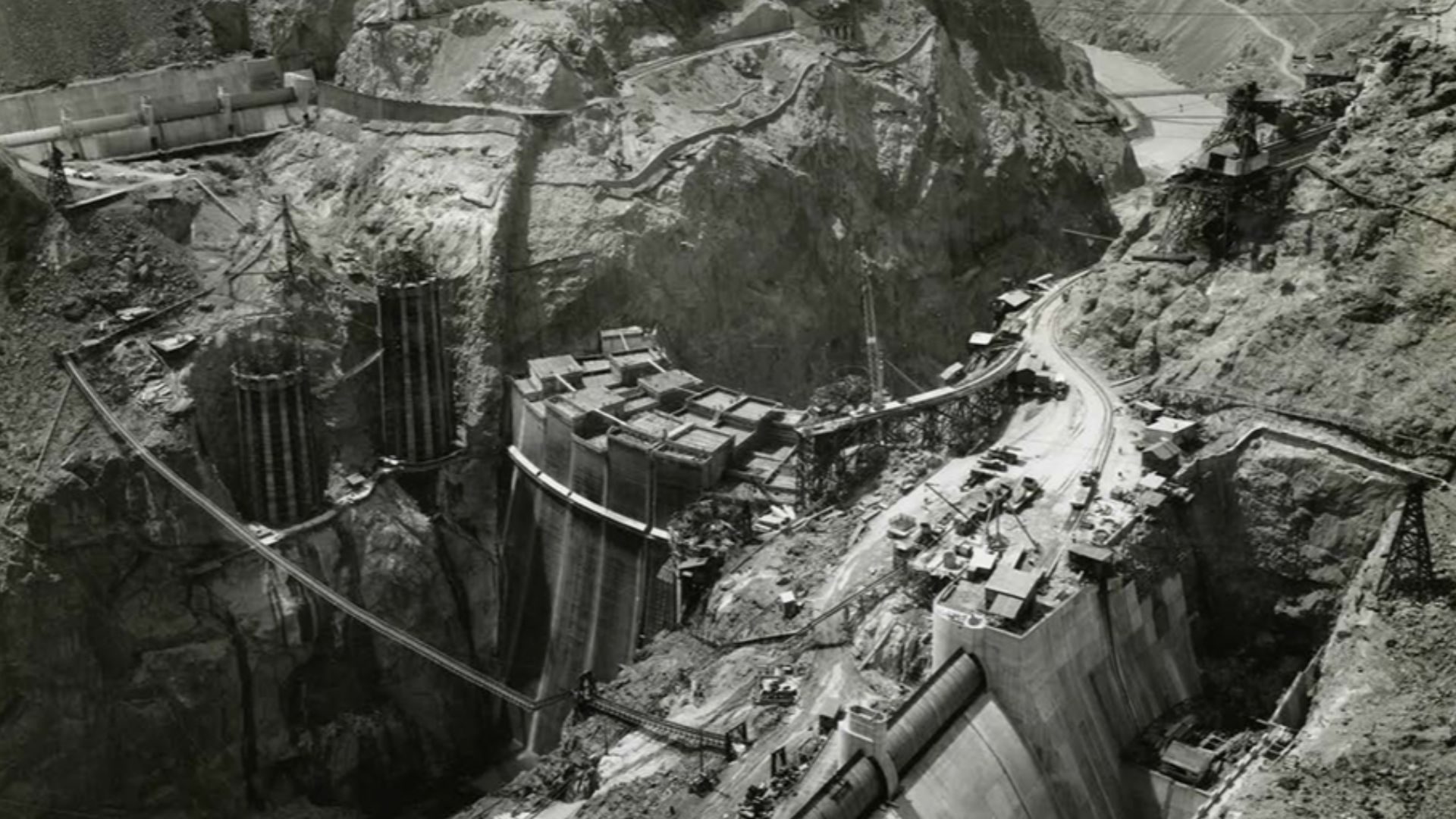 Looking downstream from the Nevada side, toward the upstream face of Boulder Dam, showing the Spillways, Arizona Intake Towers and Cableways. 08/17/1934 (31-al21-134)