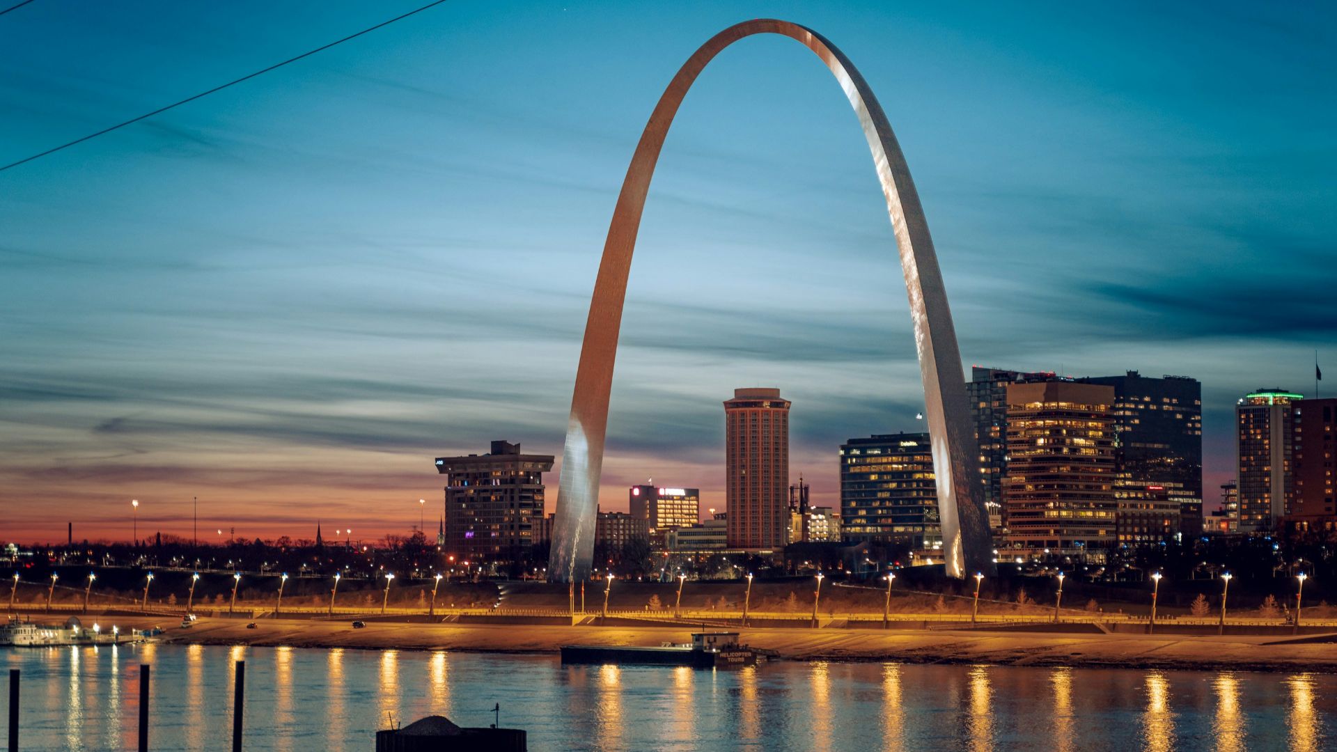 the st louis arch is lit up at night