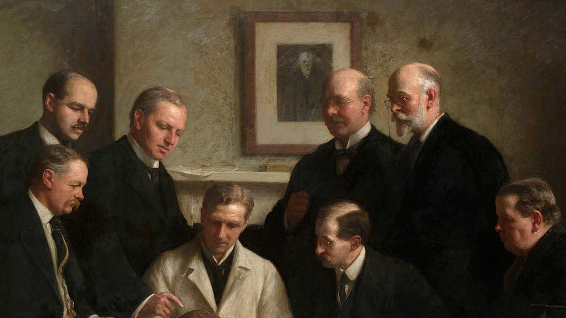 The portrait painted by John Cooke in 1915. Back row: (left to right) F. O. Barlow, G. Elliot Smith, Charles Dawson, Arthur Smith Woodward. Front row: A. S. Underwood, Arthur Keith, W. P. Pycraft, and Sir Ray Lankester. Note the painting of Charles Darwin