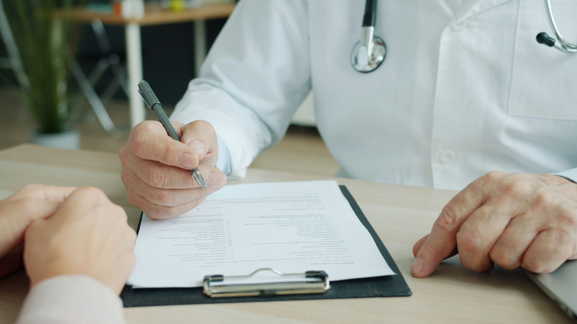 Doctor writing on a patient's chart