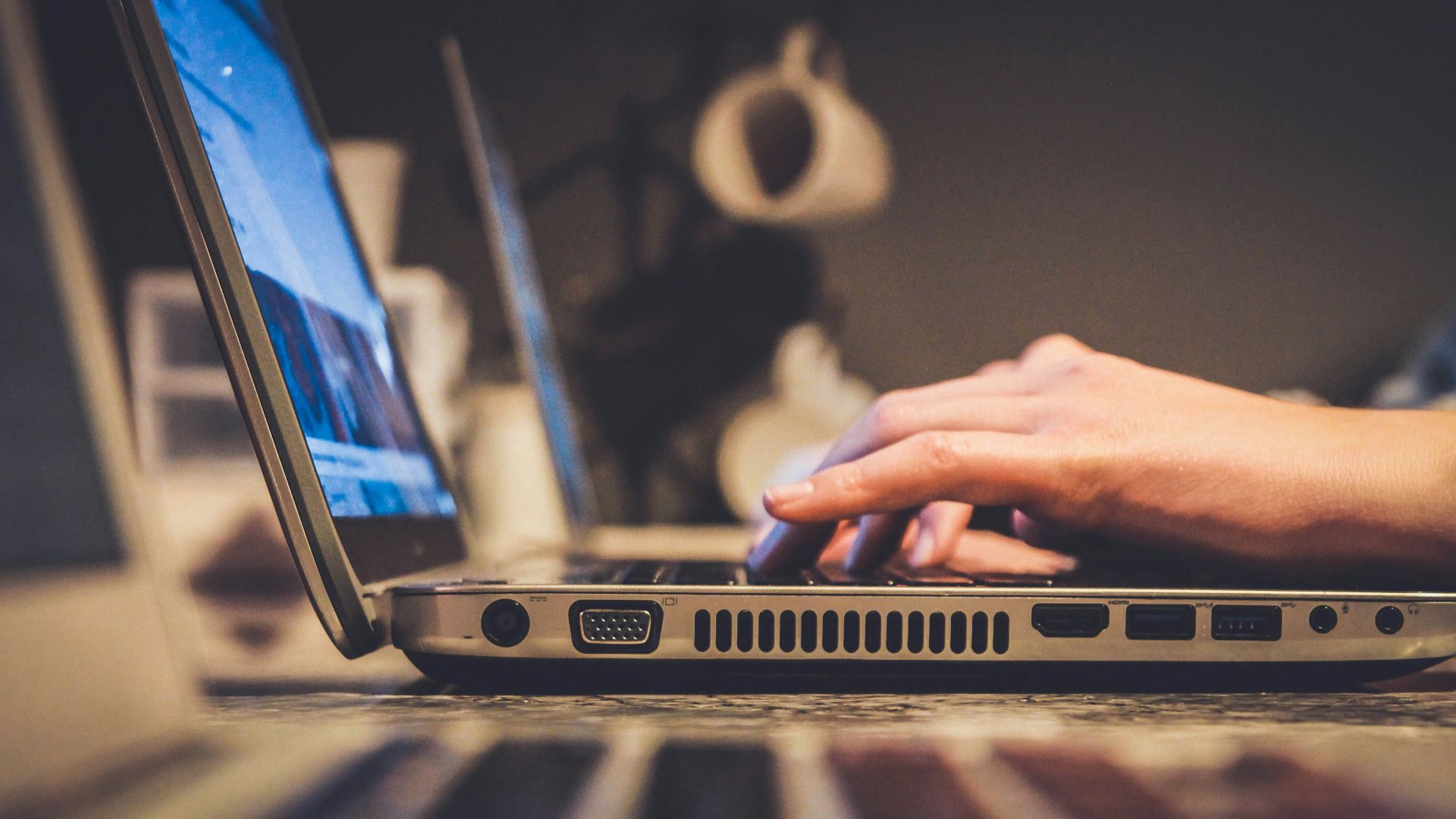 person using silver laptop computer on desk