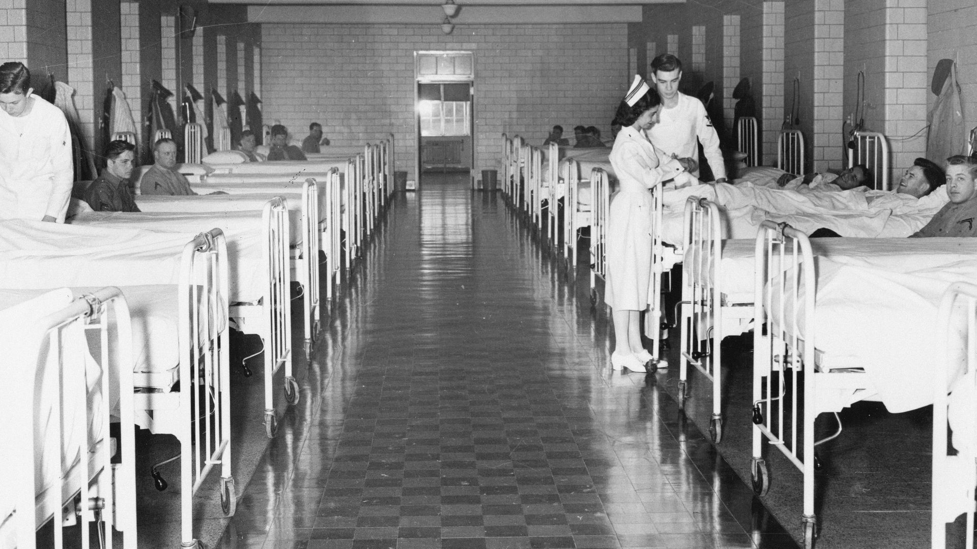 Nurses attend to patients in a hospital ward.