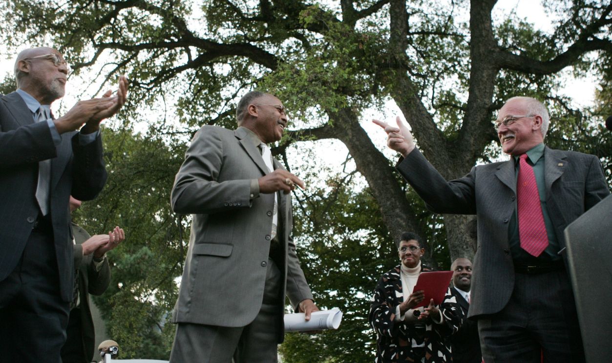 SAN JOSE, CALIFORNIA - OCTOBER 17: Peter Norman, Olympic medalist and activist, right, gives tribute to John Carlos, left, and Tommie Smith, both San Jose State University alumni, Olympic medalists and activists at an unveiling ceremony at San Jose State University in San Jose, California on Monday, October 17, 2005. The University unveiled at statue honoring the protest during the medal ceremony at the 1968 Olympics of San Jose State sprinters Tommie Smith and John Carlos.