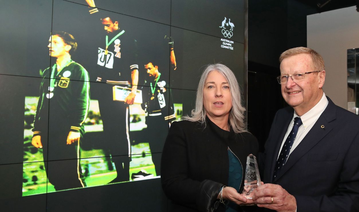 MELBOURNE, AUSTRALIA - JUNE 22: The family of the late Olympian Peter Norman, represented by his daughter Janita Norman, pose with AOC President John Coates during a posthumous Order of Merit presentation to the family of Olympic silver medallist Peter Norman at the National Sports Museum at the Melbourne Cricket Ground on June 22, 2018 in Melbourne, Australia. The posthumous award, the highest given by the AOC, acknowledges Peter Norman's support for American athletes Tommie Smith and John Carlos during their silent civil rights protest on the medal dais at the 1968 Mexico Olympics as well as his athletic achievements.