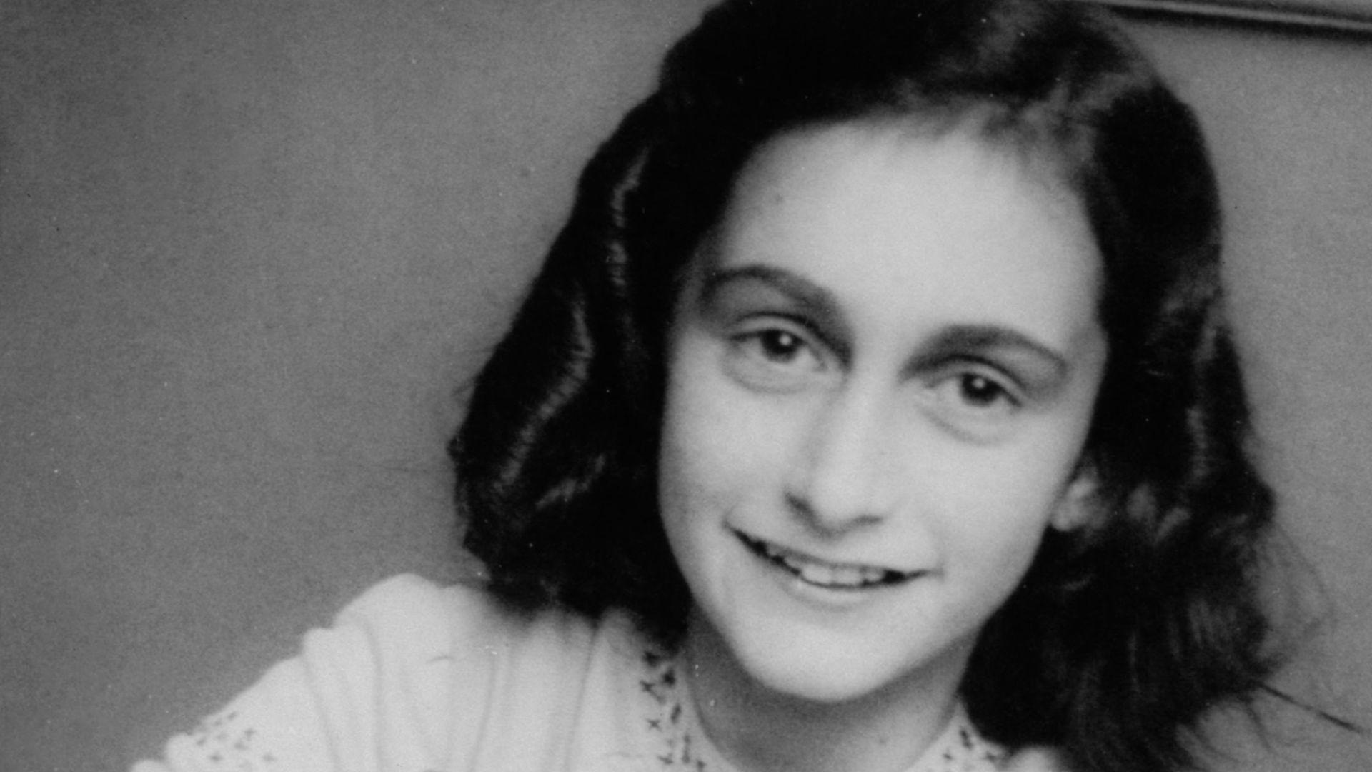 Anne Frank laughing at the school photographer. This photograph was made at the Joods Lyceum (Jewish High School Amsterdam, address Voormalige Stadstimmertuin 1), December 1941.