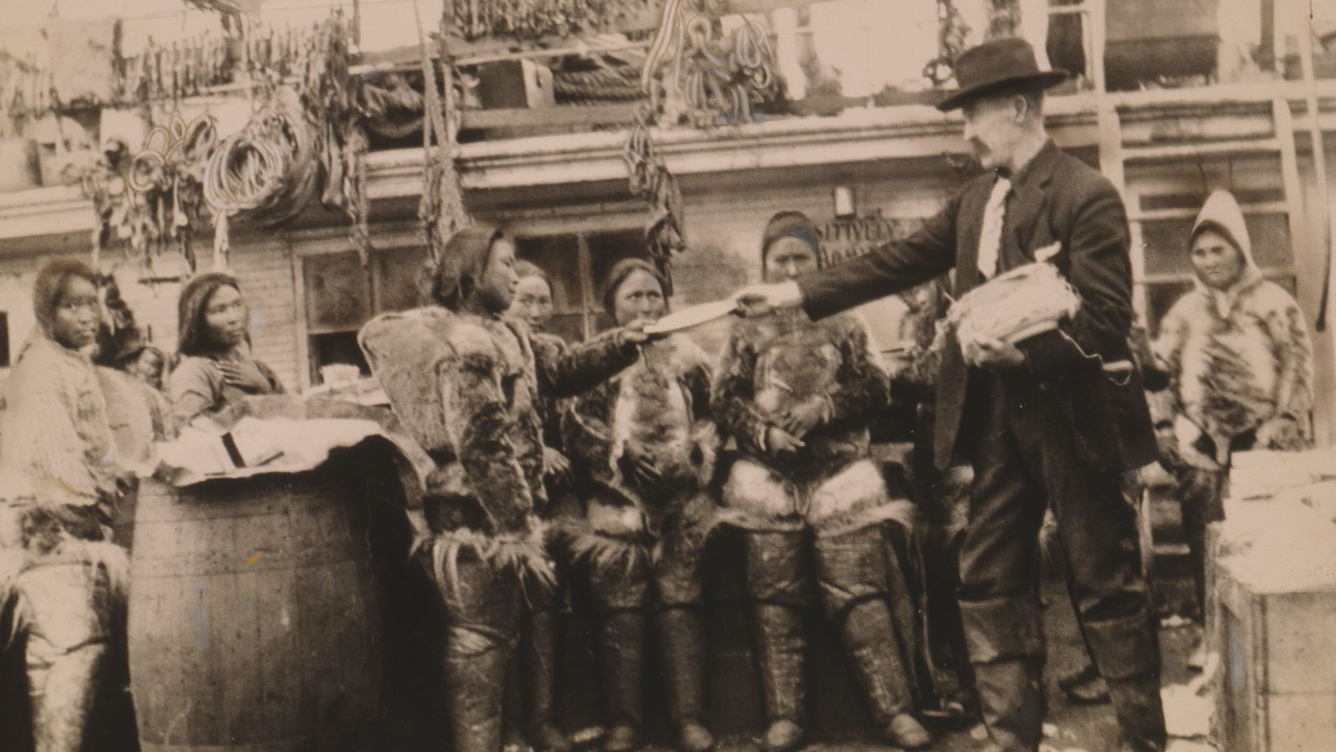 Title: Robert Edwin Peary, full-length portrait, standing on deck of ship or dock, facing left, distributing gifts to Eskimos, Greenland
Abstract/medium: 1 photographic print.