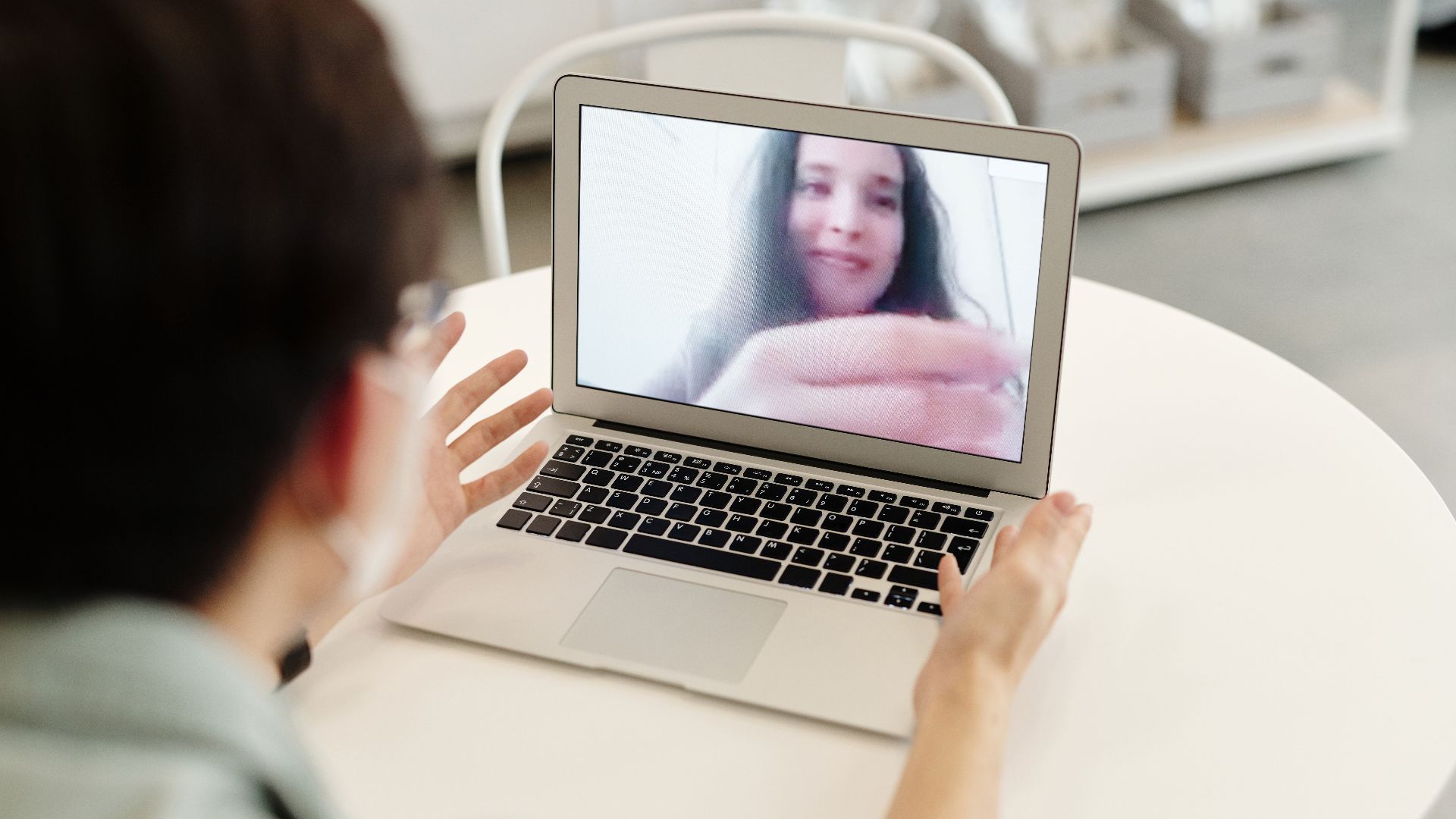 A person having a video call on a laptop, indoors, showcasing digital communication.