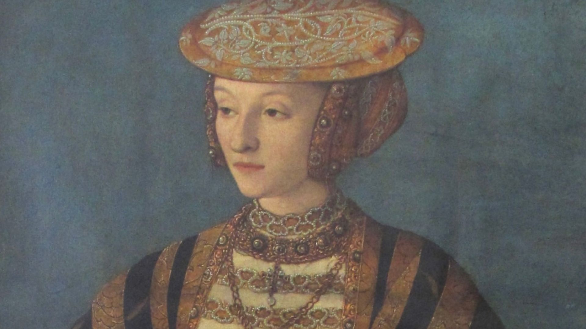 A portrait of Anne of Cleves holding two pinks, one white one reddish, and rosemary and the jewels and clothing of a Duchess of Cleves