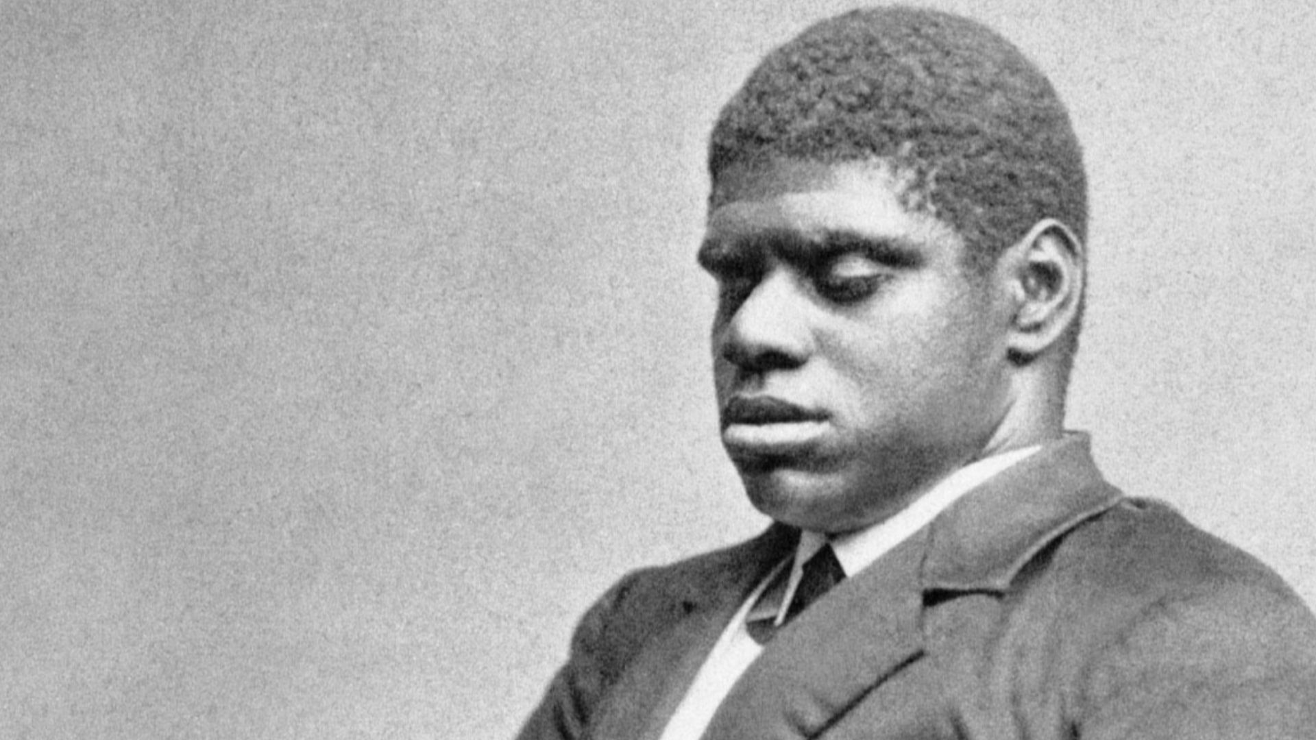 Blind Tom Wiggins seated.