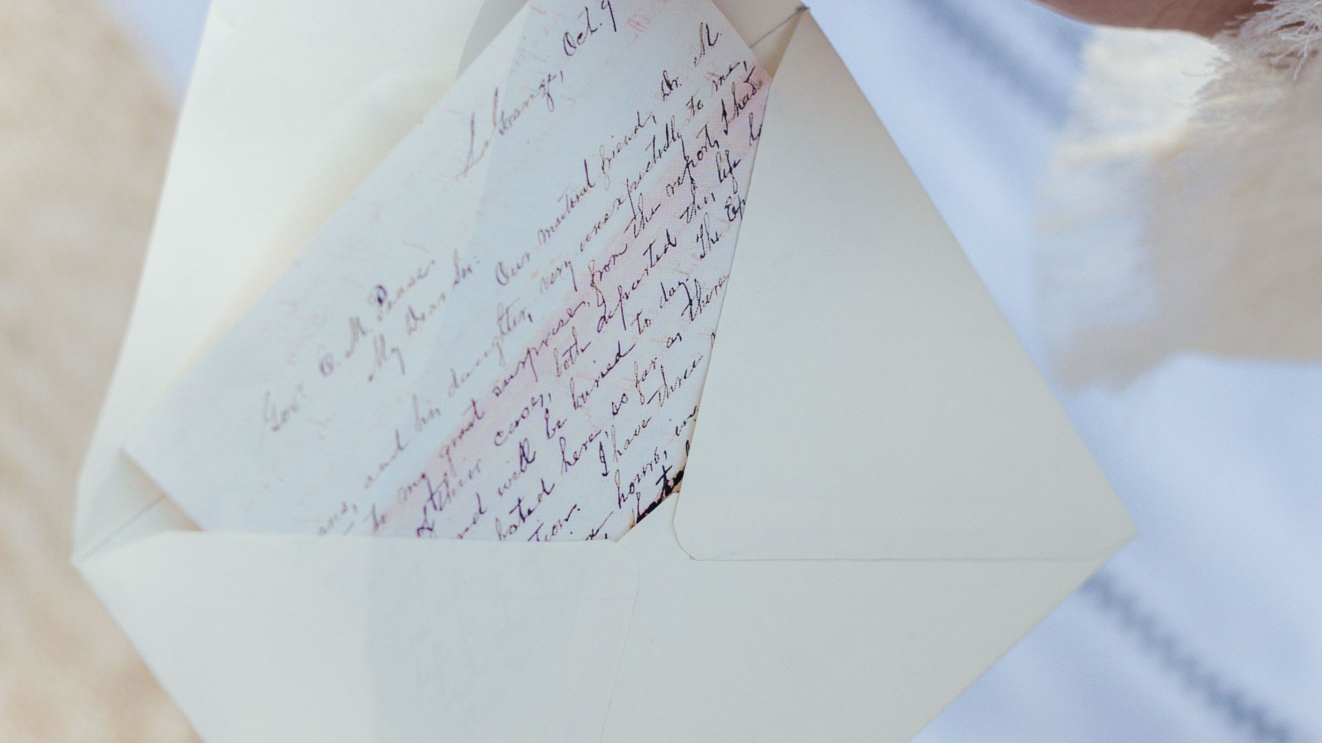 A woman's hands open an envelope containing a handwritten love letter, evoking nostalgia and romance.