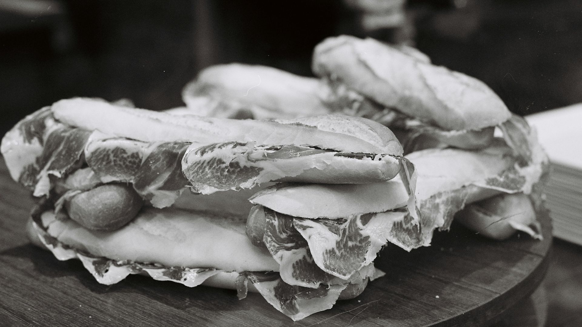 A pile of sandwiches on a wooden board