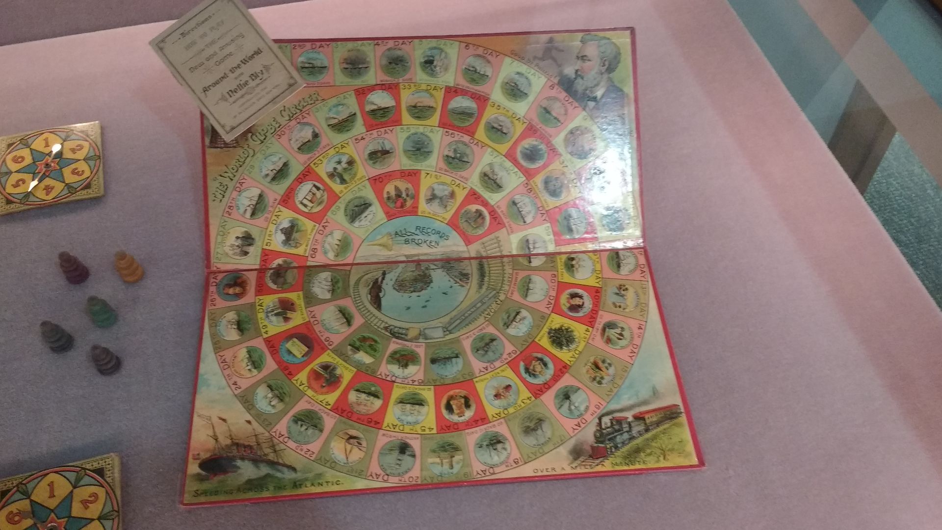 Round the World Nellie Bly board game, board and pieces. Round the World with Nellie Bly is a board game which was published in 1890 by McLoughlin Bros., New York, in celebration of Nellie Bly's circumnavigation of the globe in record time, between Novemb