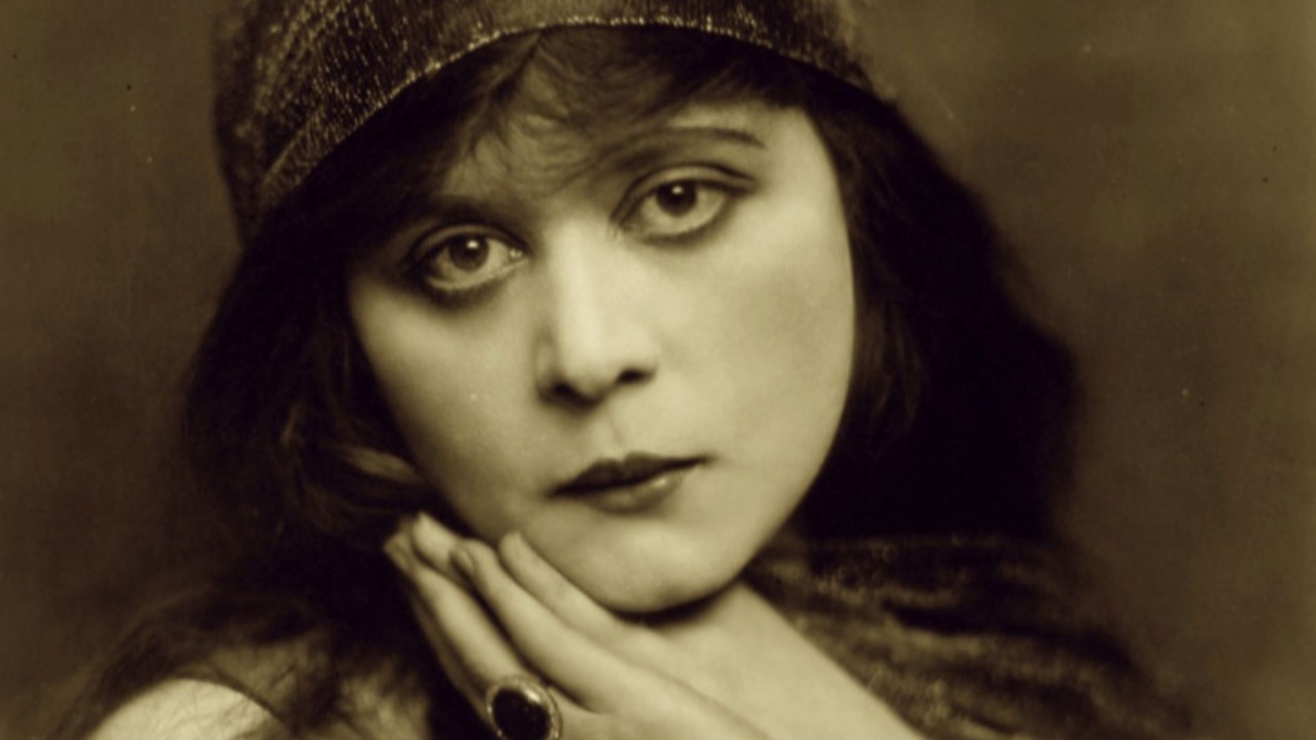 Portrait of Theda Bara with hands held under her chin.