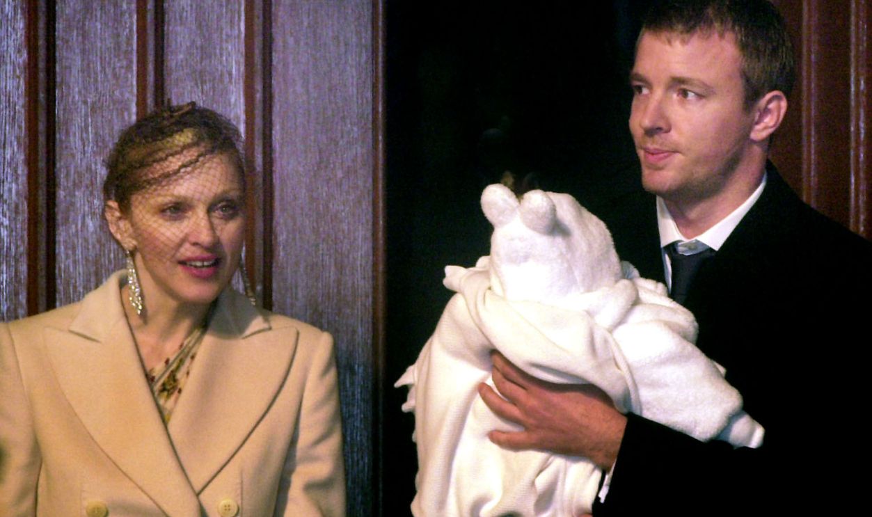 American singer Madonna and British film director Guy Ritchie with their four-month-old baby son Rocco, wrapped in a white christening gown, after the baby was christened at Dornoch Cathedral in Sutherland, Scotland. 