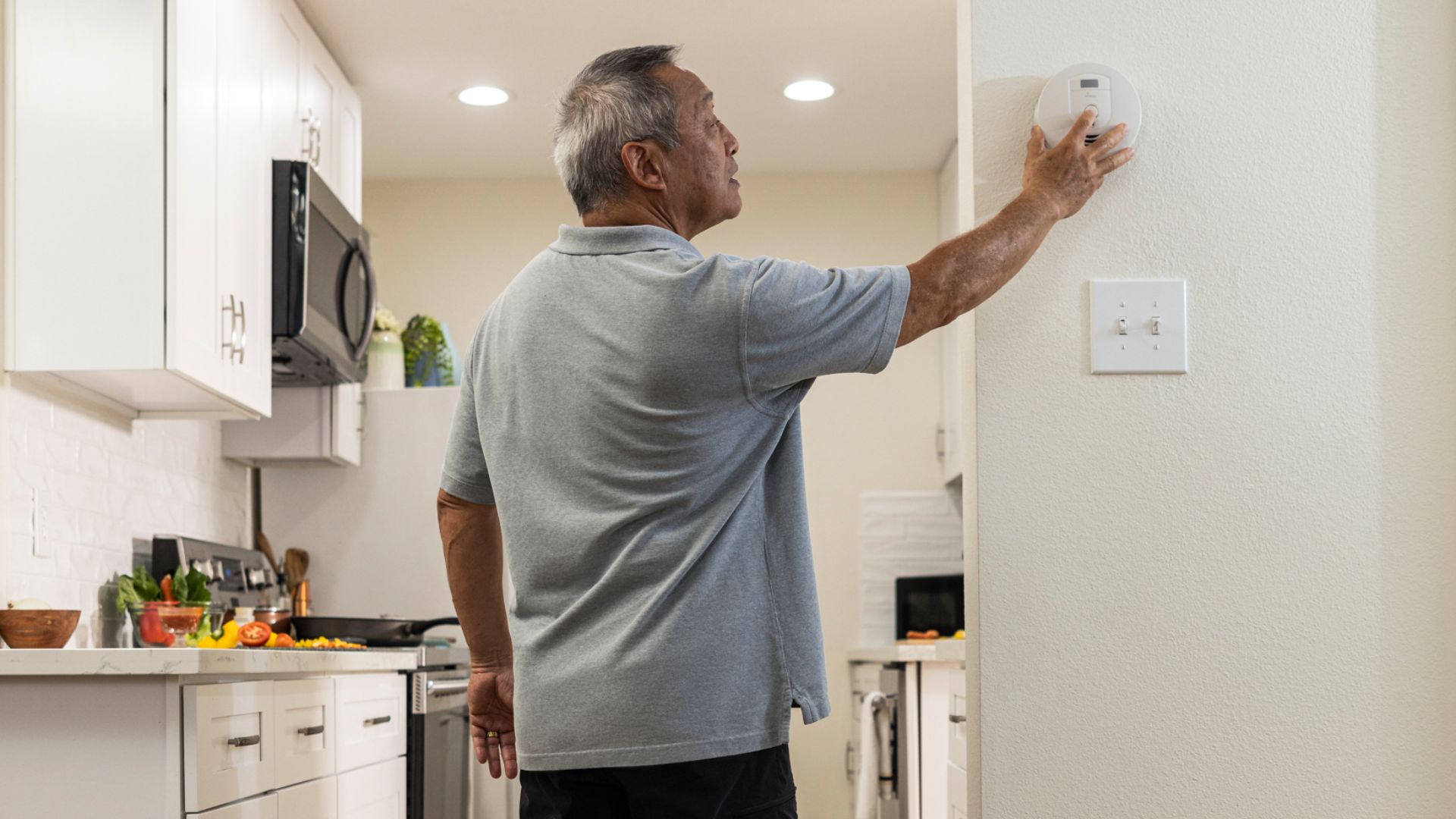 Fire Safety - Person with a prosthetic leg testing their smoke alarm.