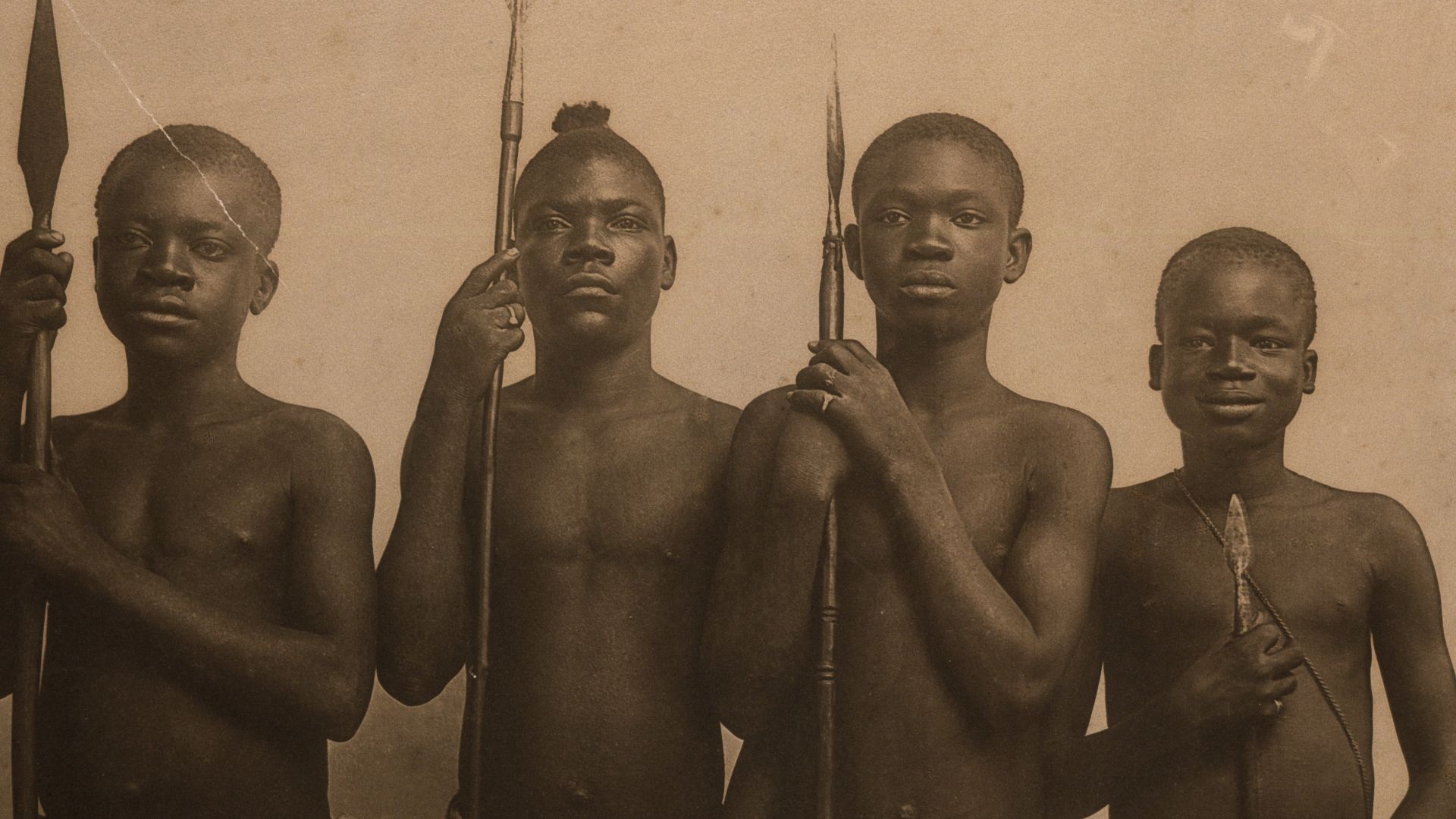 Title: Four Pygmies posing with spears. Ota Benga on right. (Taken during the 1904 World's Fair).