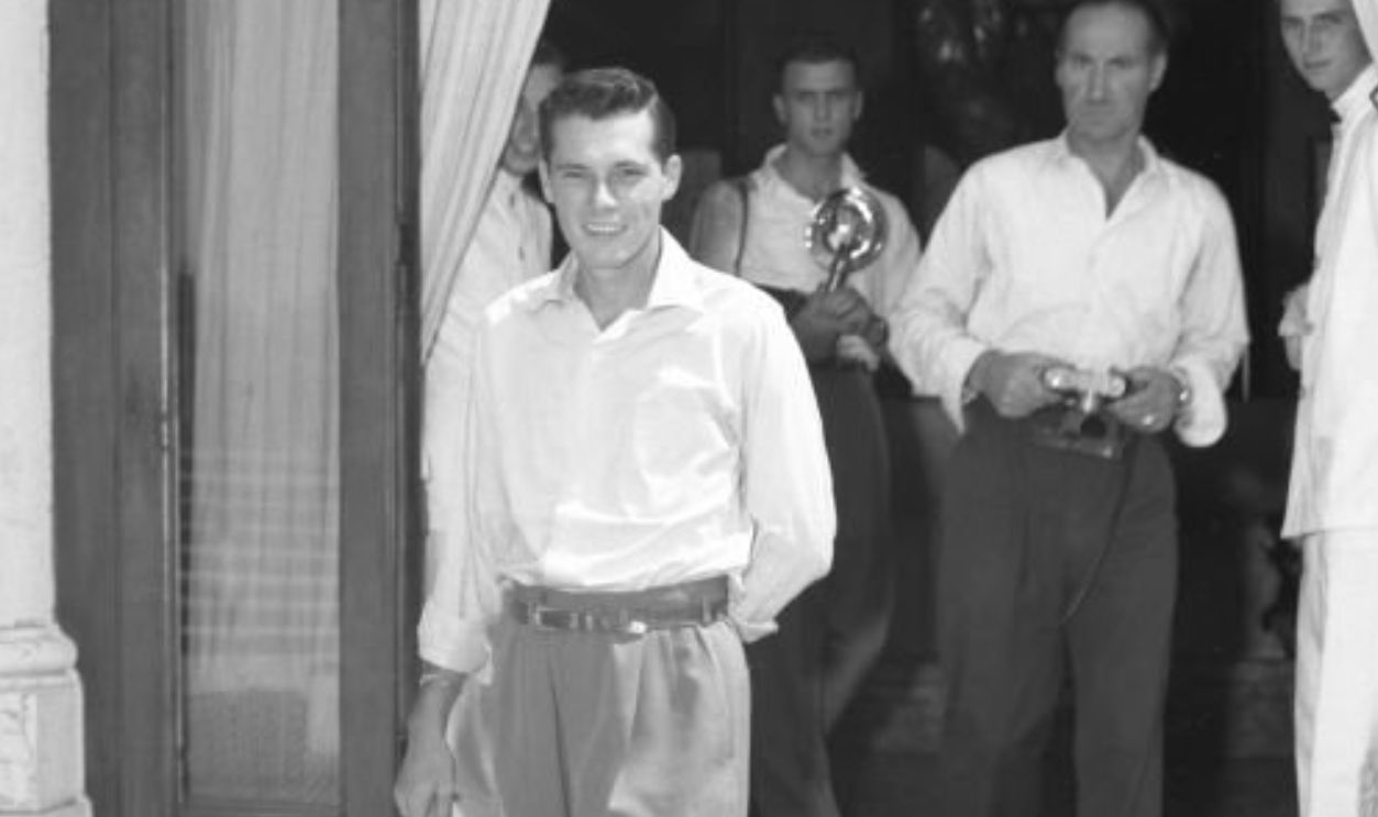 Heir Conrad 'Nicky' Hilton, first husband of Elizabeth Taylor, walking out of a building, followed by photographers, Venice, 1950. 