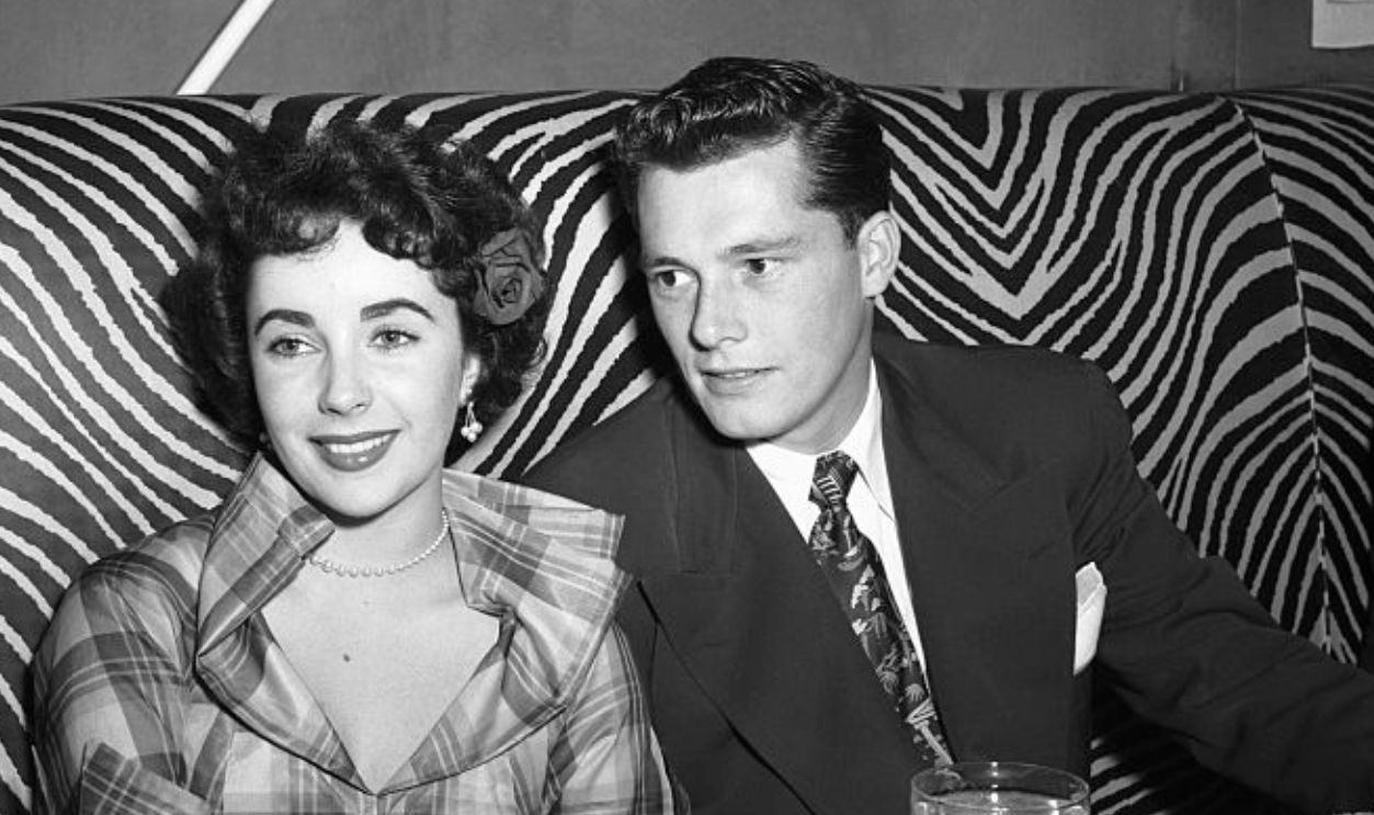 Elizabeth Taylor sits with Conrad Hilton Jr. in a booth at the El Morocco nightclub.
