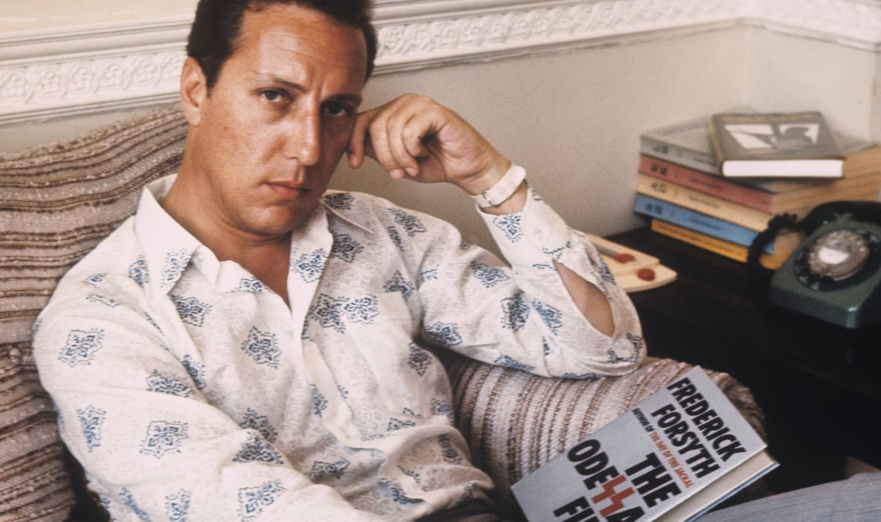 Frederick Forsyth, author, pictured with a copy of his 1972 novel, The Odessa File, circa 1972.
