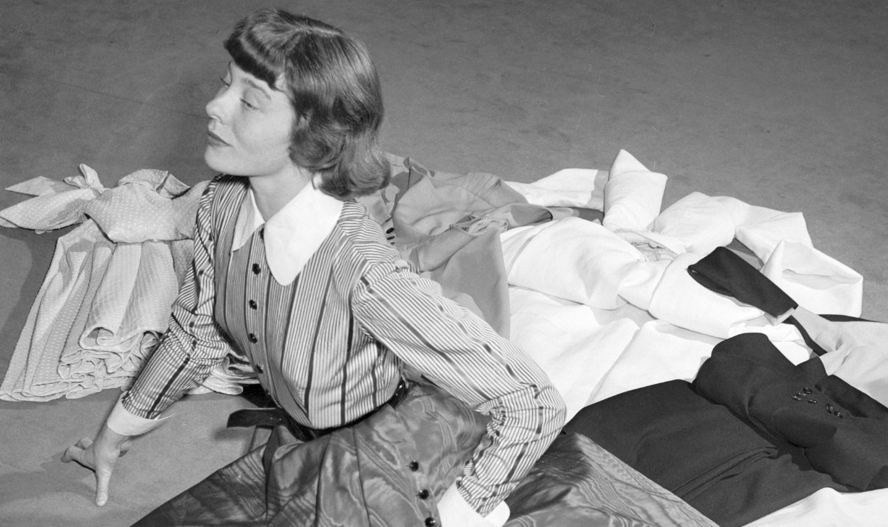 In Rita's Trousseau. Paris: Model Bettina Graziani shows one of the eleven Jacques Fath dresses chosen as a trousseau by screen star Rita Hayworth for her approaching marriage to Aly Khan. This gown is made of changing maroon faille, with maroon and black striped bodice, and collar and cuffs of starched white linen. Fath is also making the wedding gown.