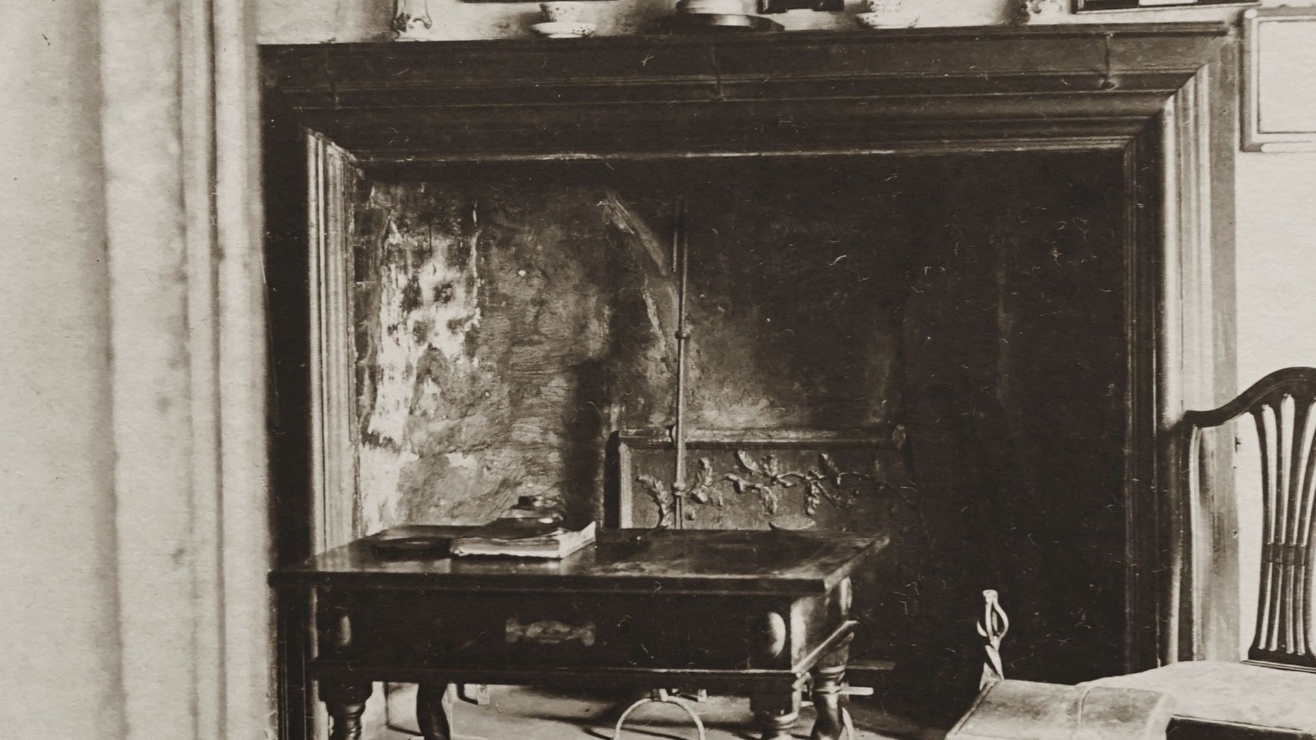 A classic vintage living room with antique furniture and historic picture frames.