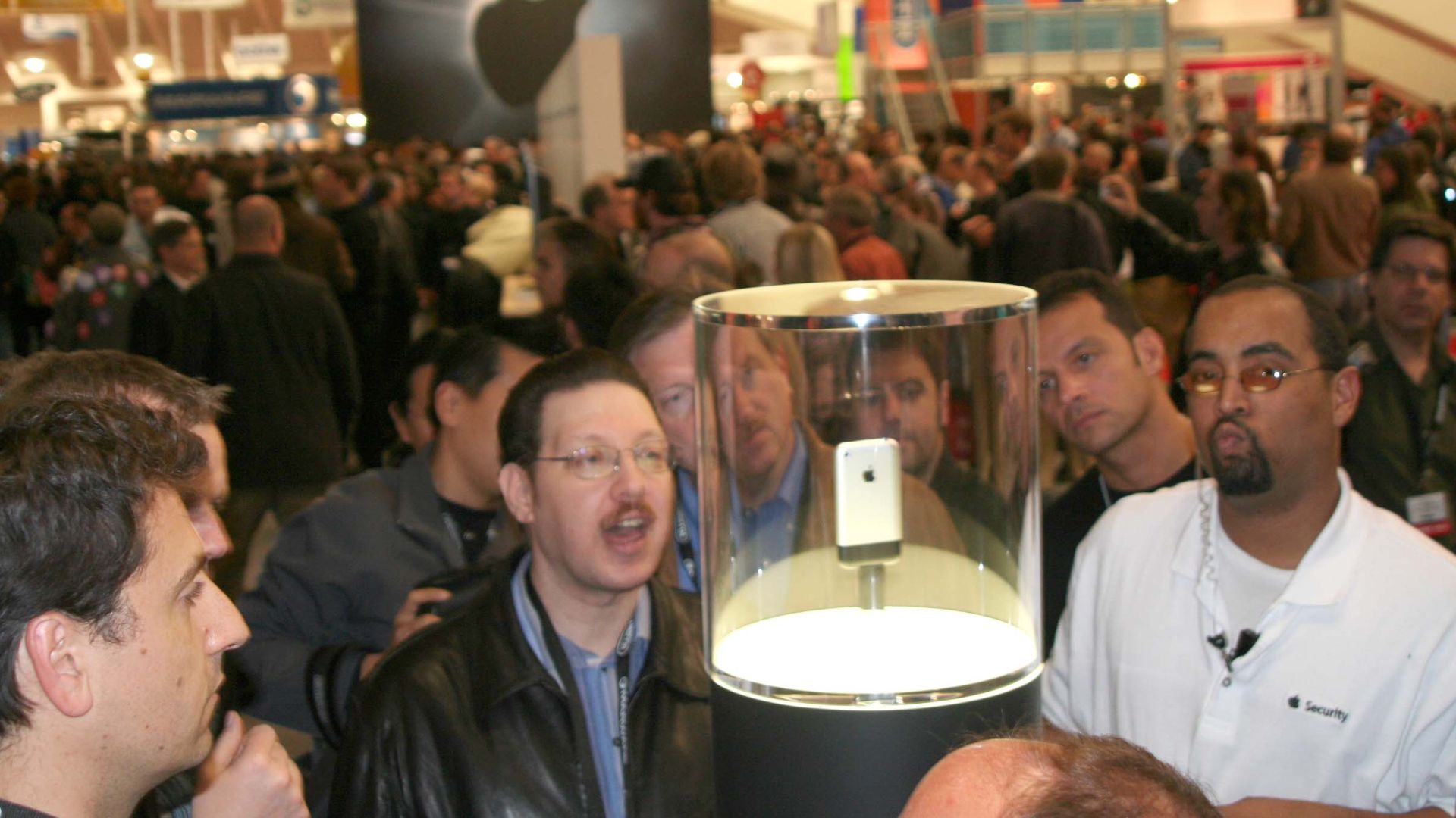 Attendees crowd the iPhone glass case on the floor of the Exhibit Hall.