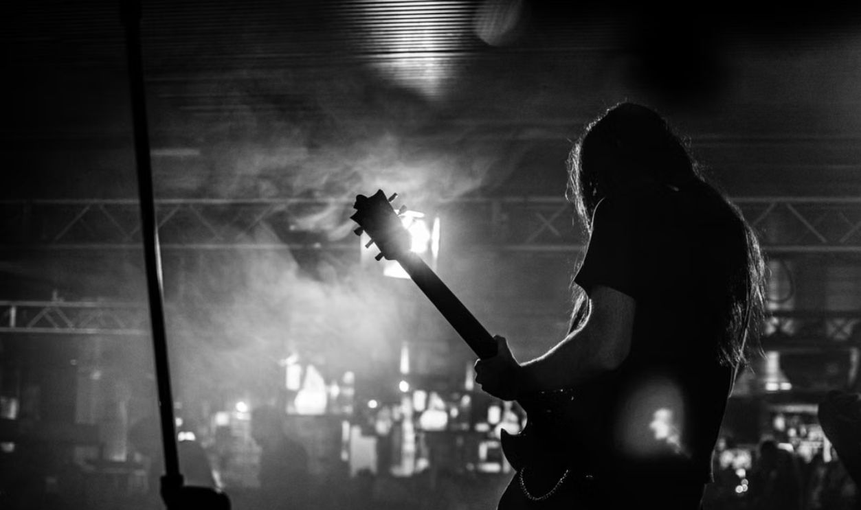 Silhouette of a guitarist performing live at a concert in Milan, Italy