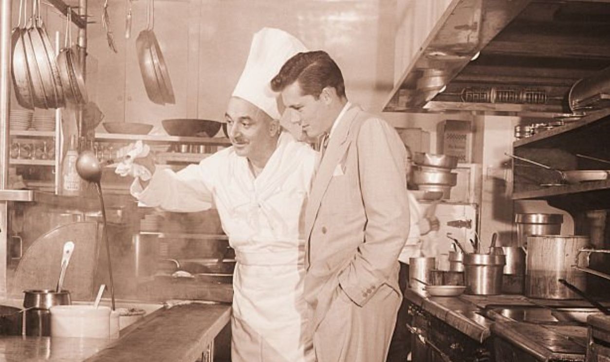 (Original Caption) 1950-Nicky Hilton is shown in a kitchen with chef Walter Luth.