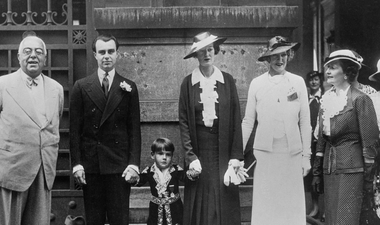 Prince Aly Khan with his bride, Joan Yarde-Buller (Princess Tajudaullah), and family members after their civil wedding ceremony in Paris, France, May 18th 1936. From left: Muhammad Aga Khan III; Prince Aly Khan; Prince Sadruddin Aga Khan, Aly Khan's brother; Joan Yarde-Buller; Princess Theresa, Aly Khan's mother; Princess Andrée Aga Khan, third wife of Aga Khan III.