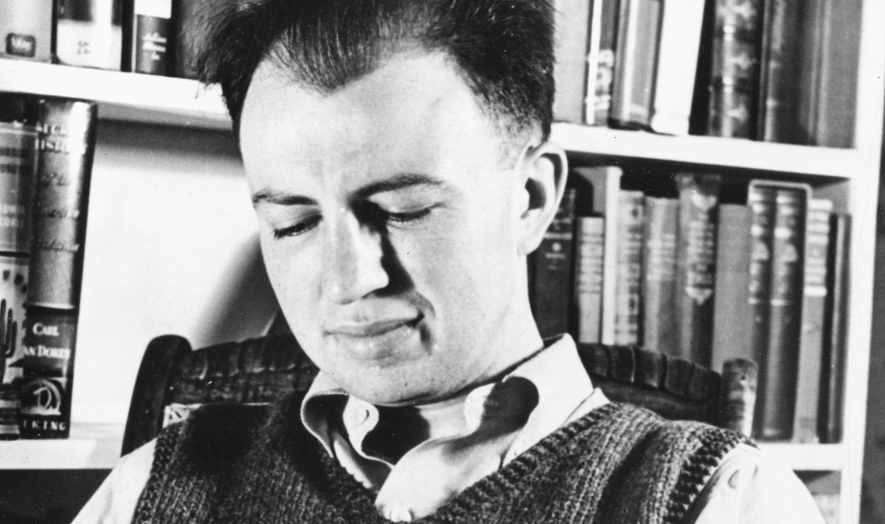Howard Fast (1914- ), liberal American novelist, reading in his library.