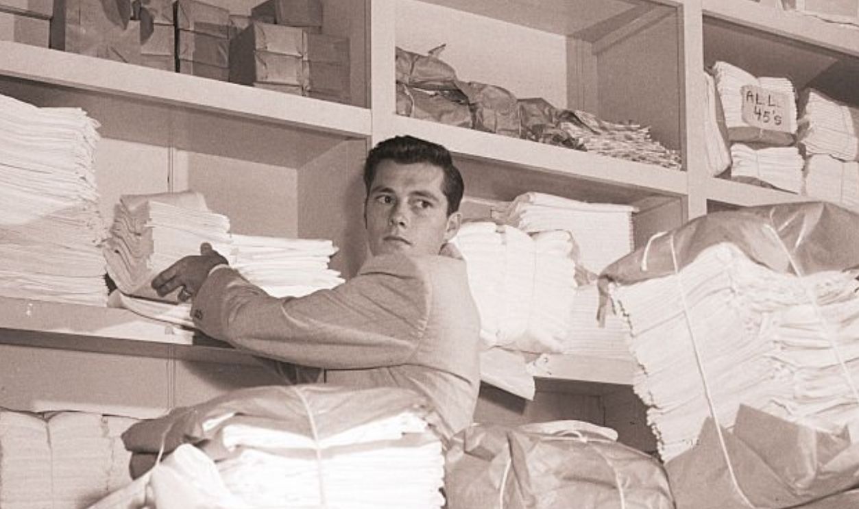 (Original Caption) 12/10/1950- Hollywood, CA- Young Nickie Hilton works as hard as, if not harder than, any of his employees. Here he is taking inventory in his linen department.