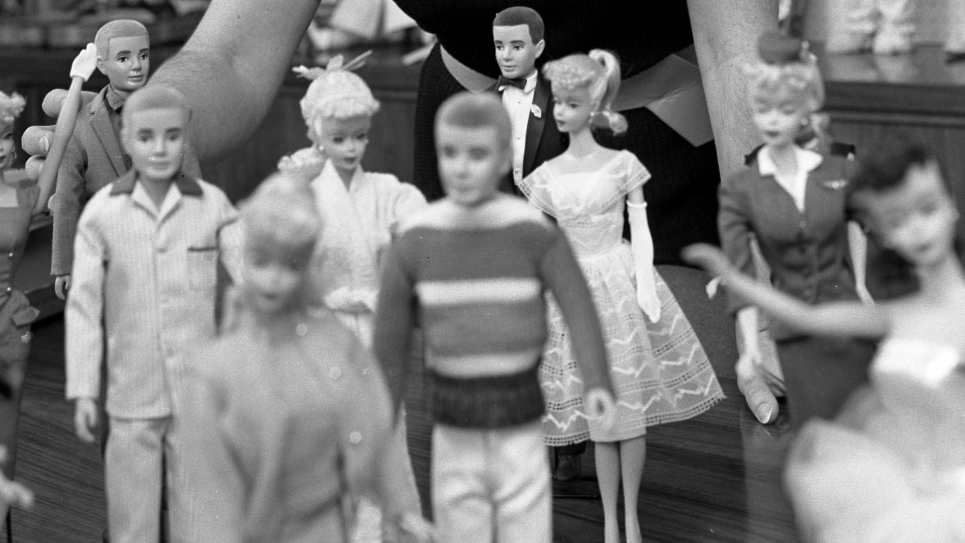 Various Barbie and Ken dolls from their first years of existence.