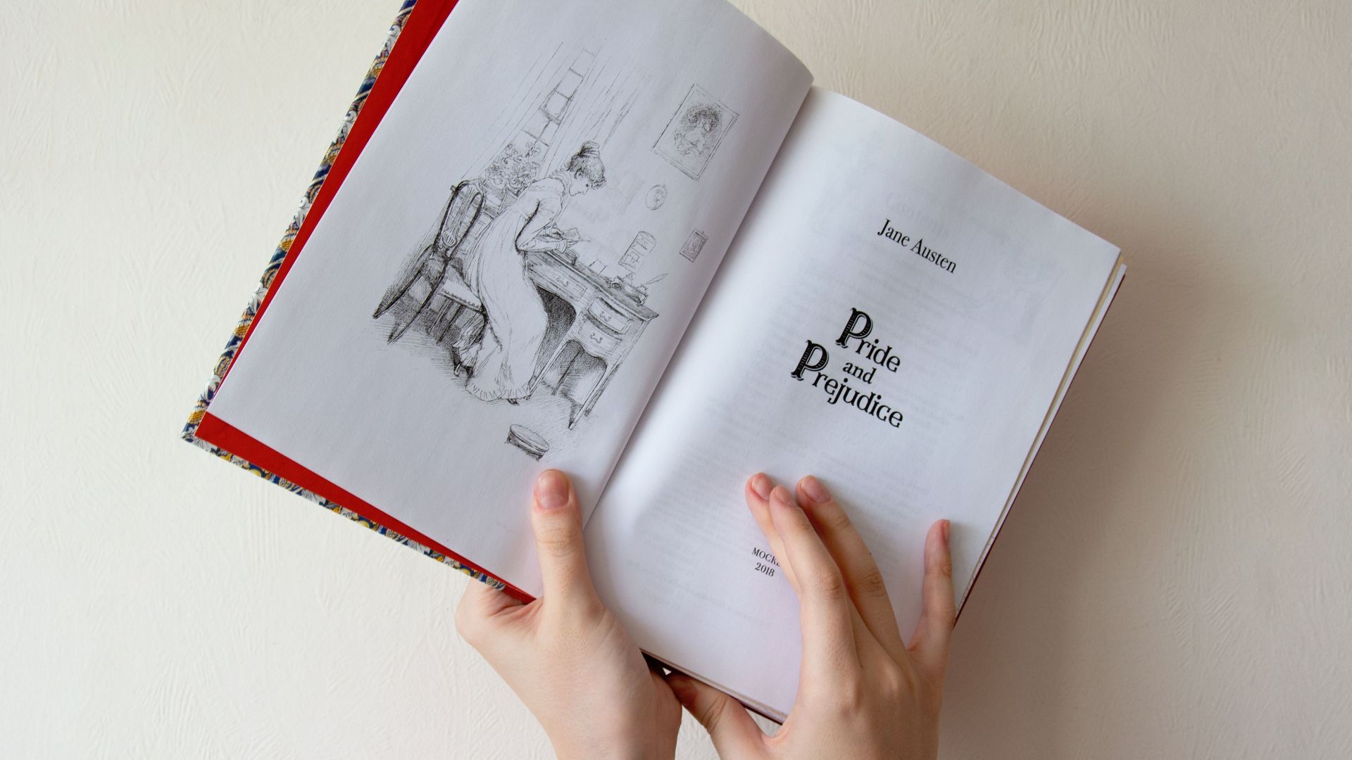 Close-up of hands holding 'Pride and Prejudice' by Jane Austen.