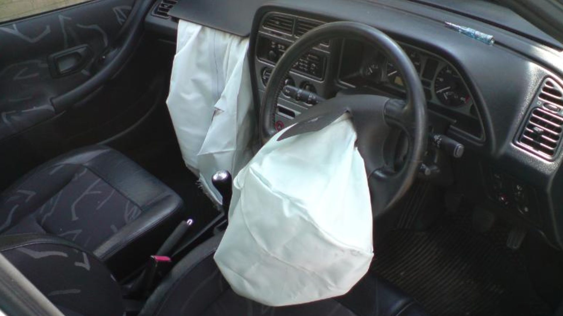 Interior photo of a Peugeot 306 with airbags deployed.