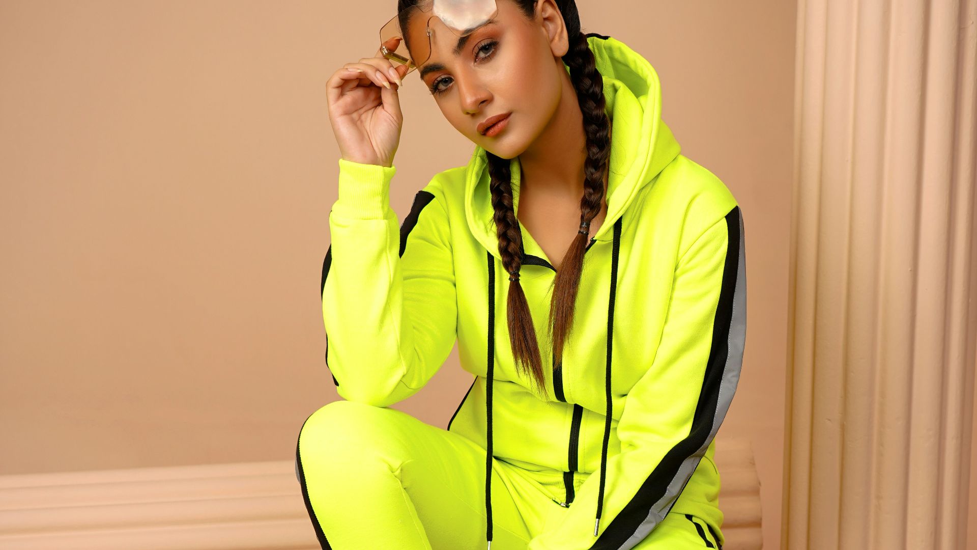 a woman sitting on a piece of wood in a yellow outfit
