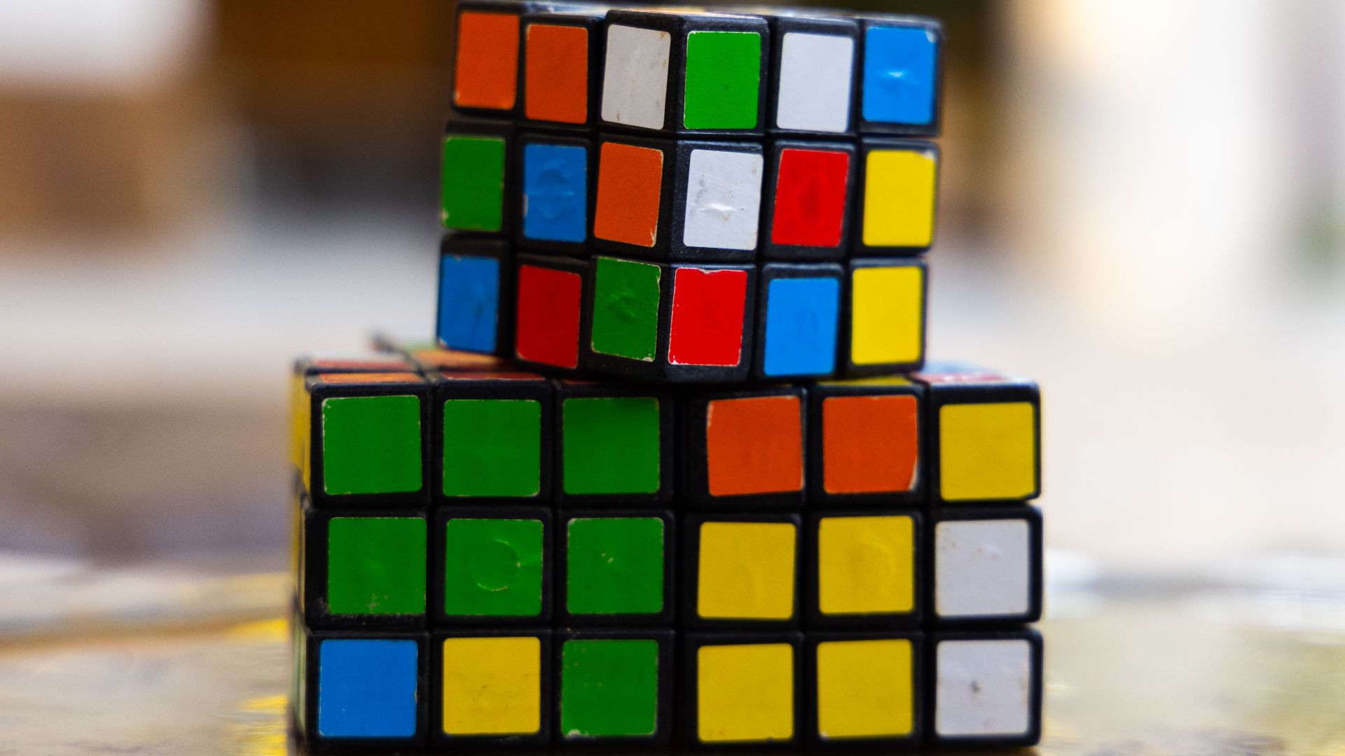 Close-up of two stacked Rubik's Cubes showcasing multi-colored squares for puzzle enthusiasts.