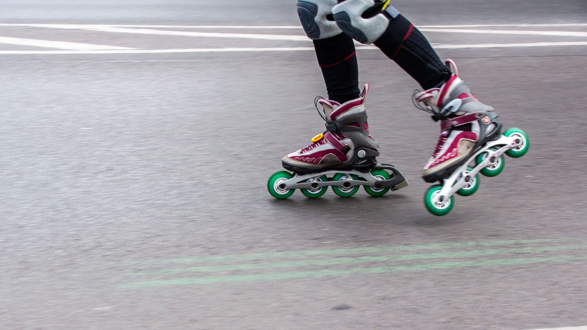 Close-up of a person rollerblading on an urban street, showcasing speed and motion.