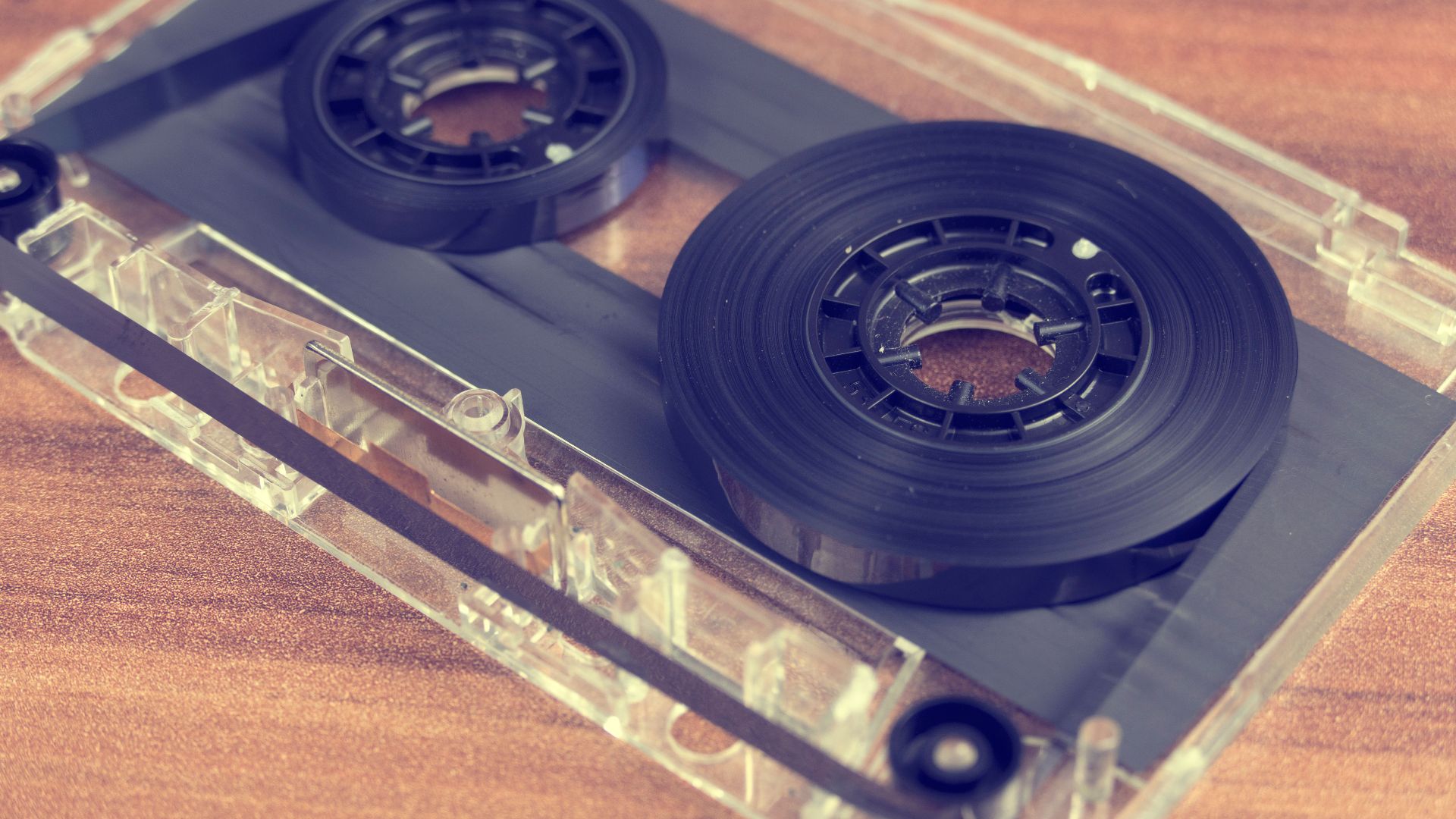 Detailed close-up of a retro audio cassette tape on a wooden surface.