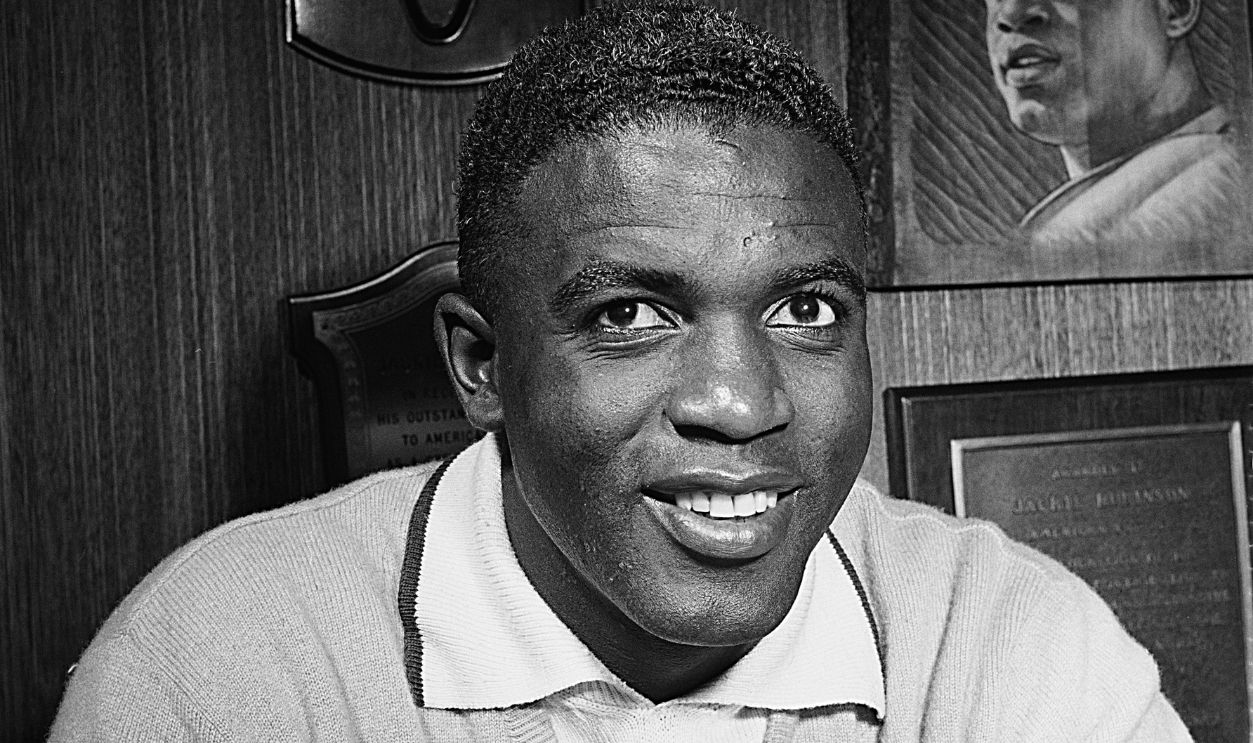 American baseball player Jackie Robinson (1919 - 1972) with plaques commemorating his success, circa 1955
