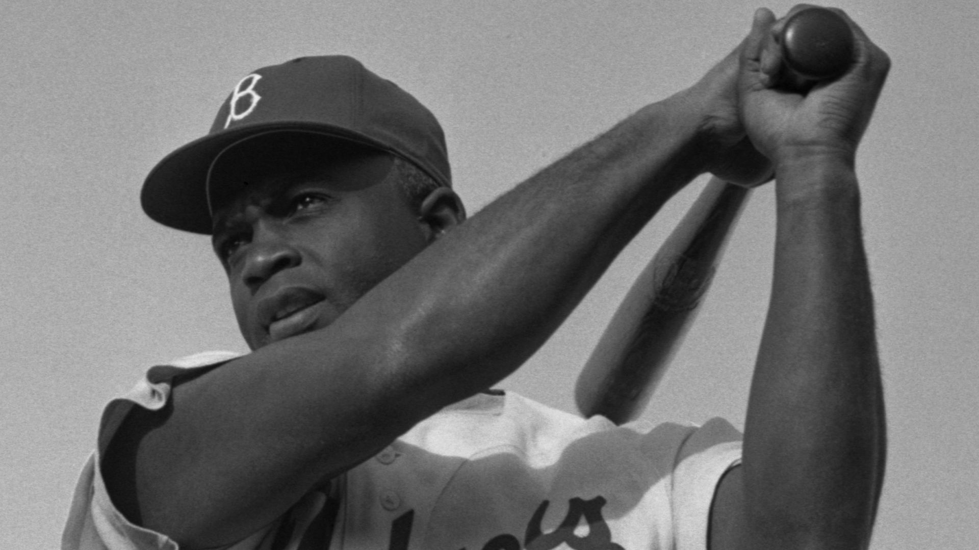 Jackie Robinson swinging a bat in Dodgers uniform, 1954.