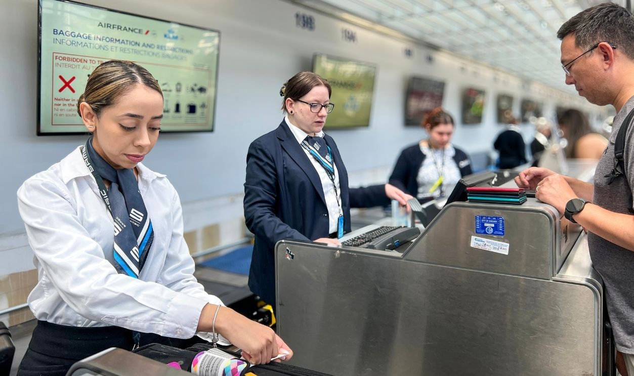 Chicago, Illinois, July 17, 2023 Passengers check in for their flights at the airport check-in counter. An airline employee checks in luggage for the passenger. O'Hare International Airport.