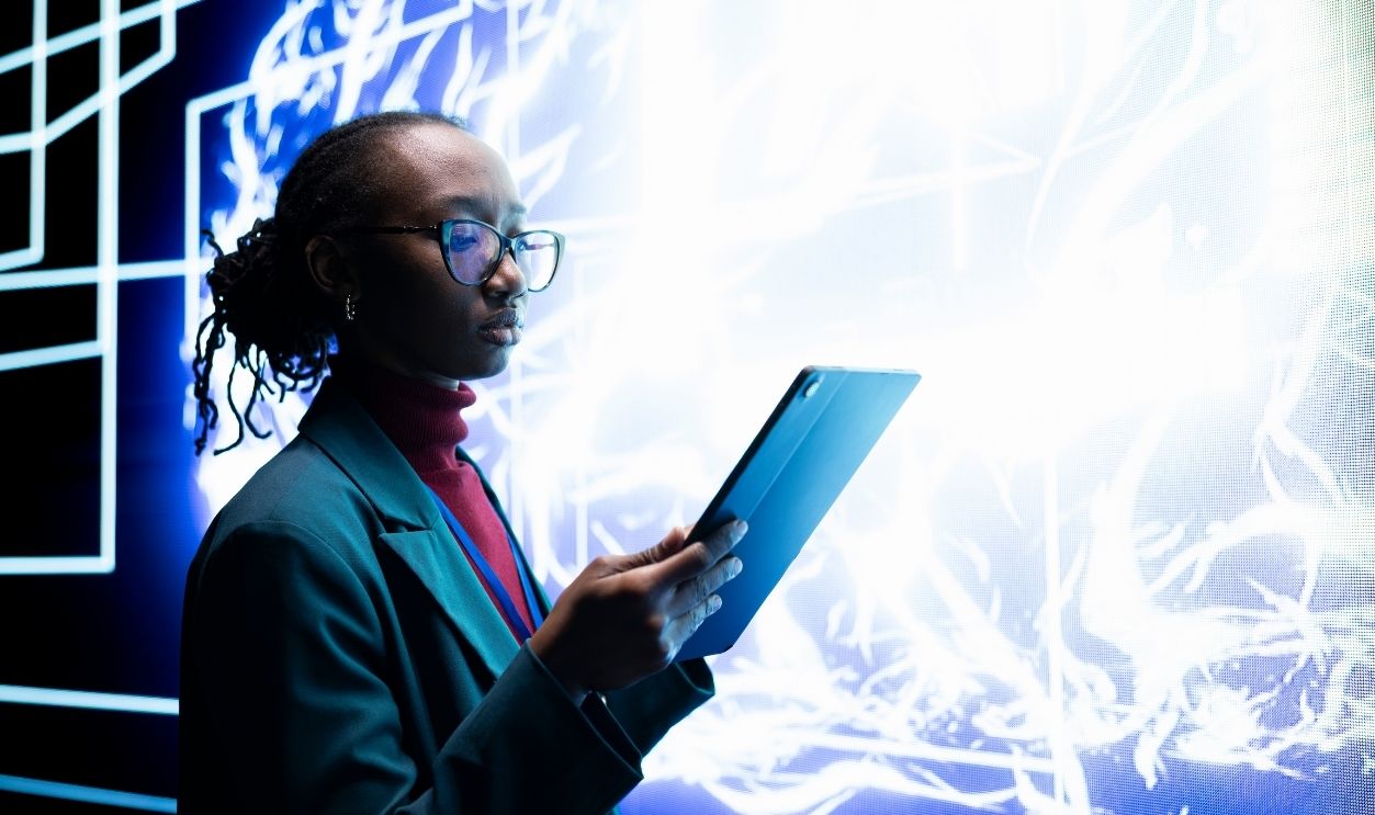 Software developer seeing autonomous AI agent writing complex code on digital videowall. Close up of system administrator tracking self generating artificial intelligence architecture on tablet