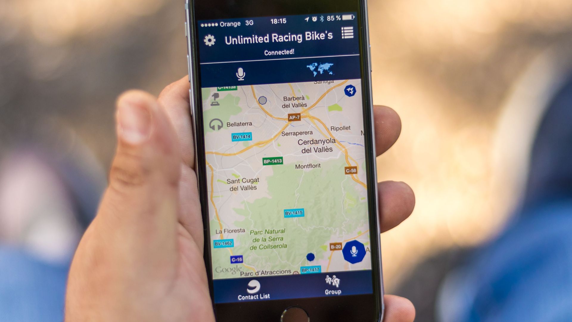Hand holding smartphone displaying a GPS map application with location data.