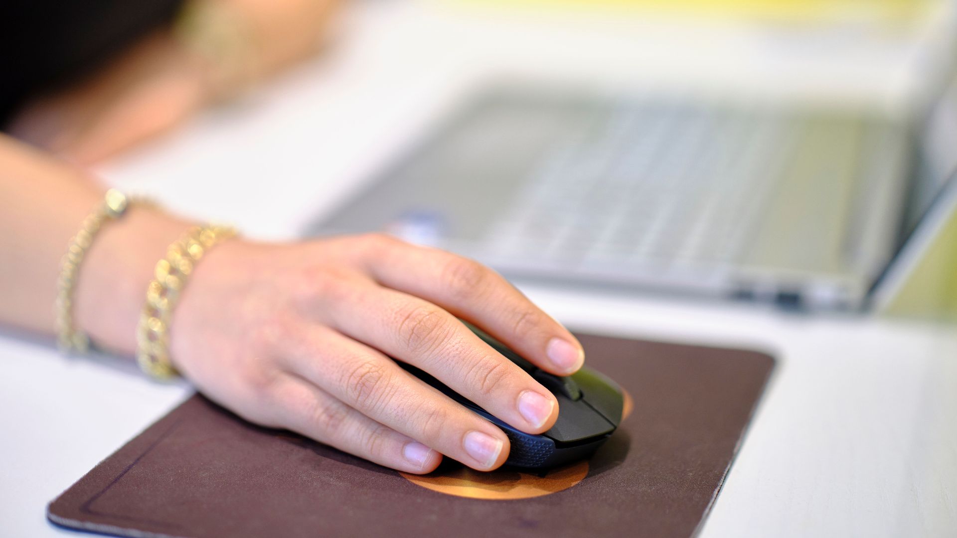 A person using a wireless mouse at a desk, perfect for business or technology themes.
